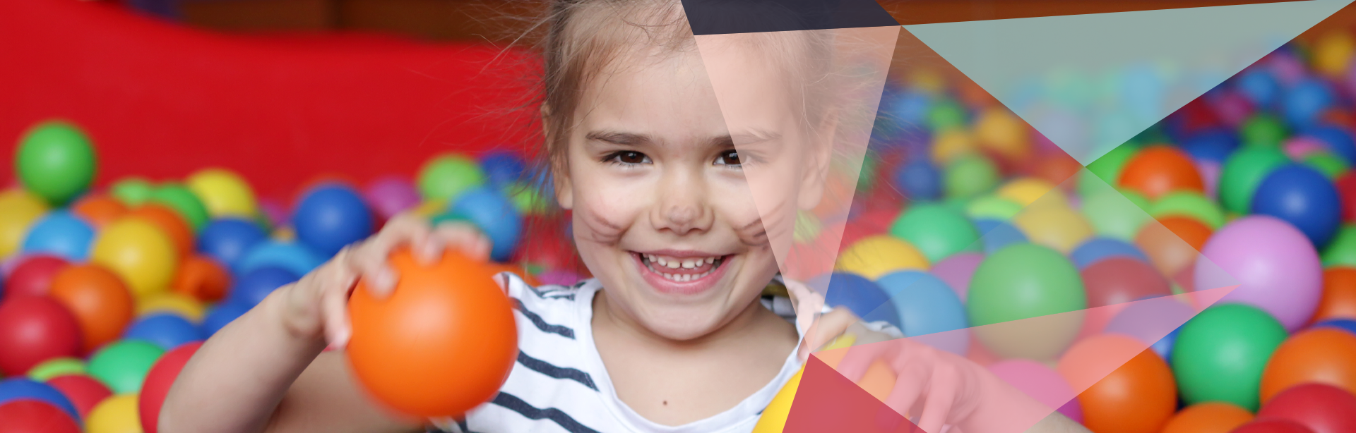 Young girl with face paint in a ball pit